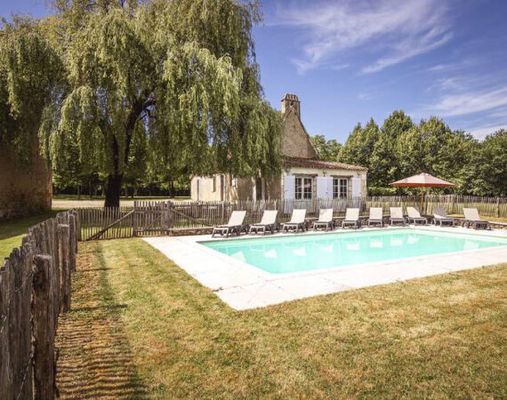 Pool with deck chairs and tree at Belpech villa in Dordogne