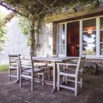 Les étables la terrasse couverte avec une table et 4 chaises au Domaine de la Léotardie Dordogne France